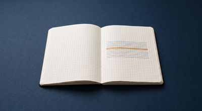 An open grid ledger on a sparse desk with one row picked out by a single warm amber marker.