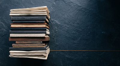 An overhead flat-lay of compact objects stacked and accumulating on one side, fading into shadow on the other.